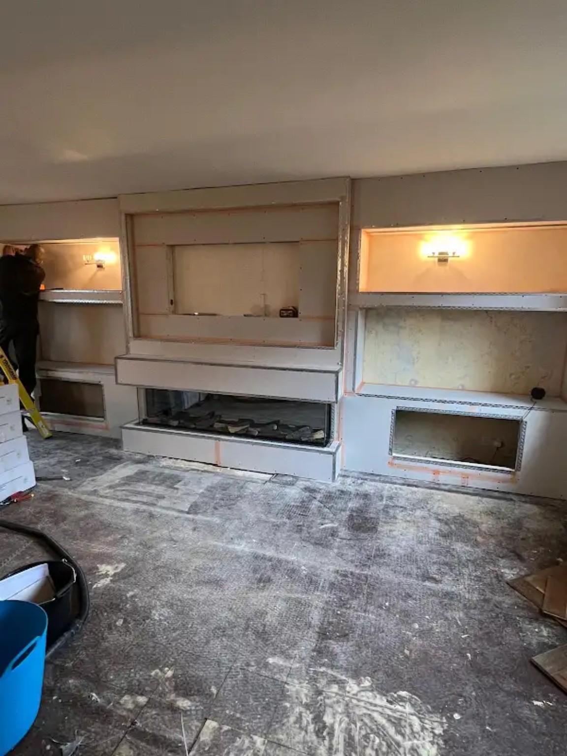 Media wall under construction in plasterboard with the long fireplace opening and alcoves framed out