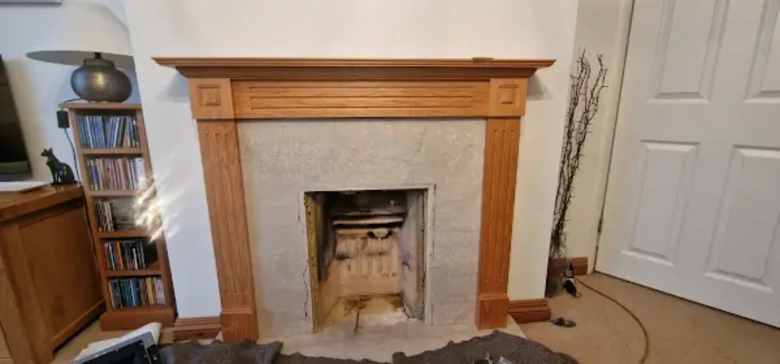 Oak fireplace surround with the old gas fire removed leaving an empty opening